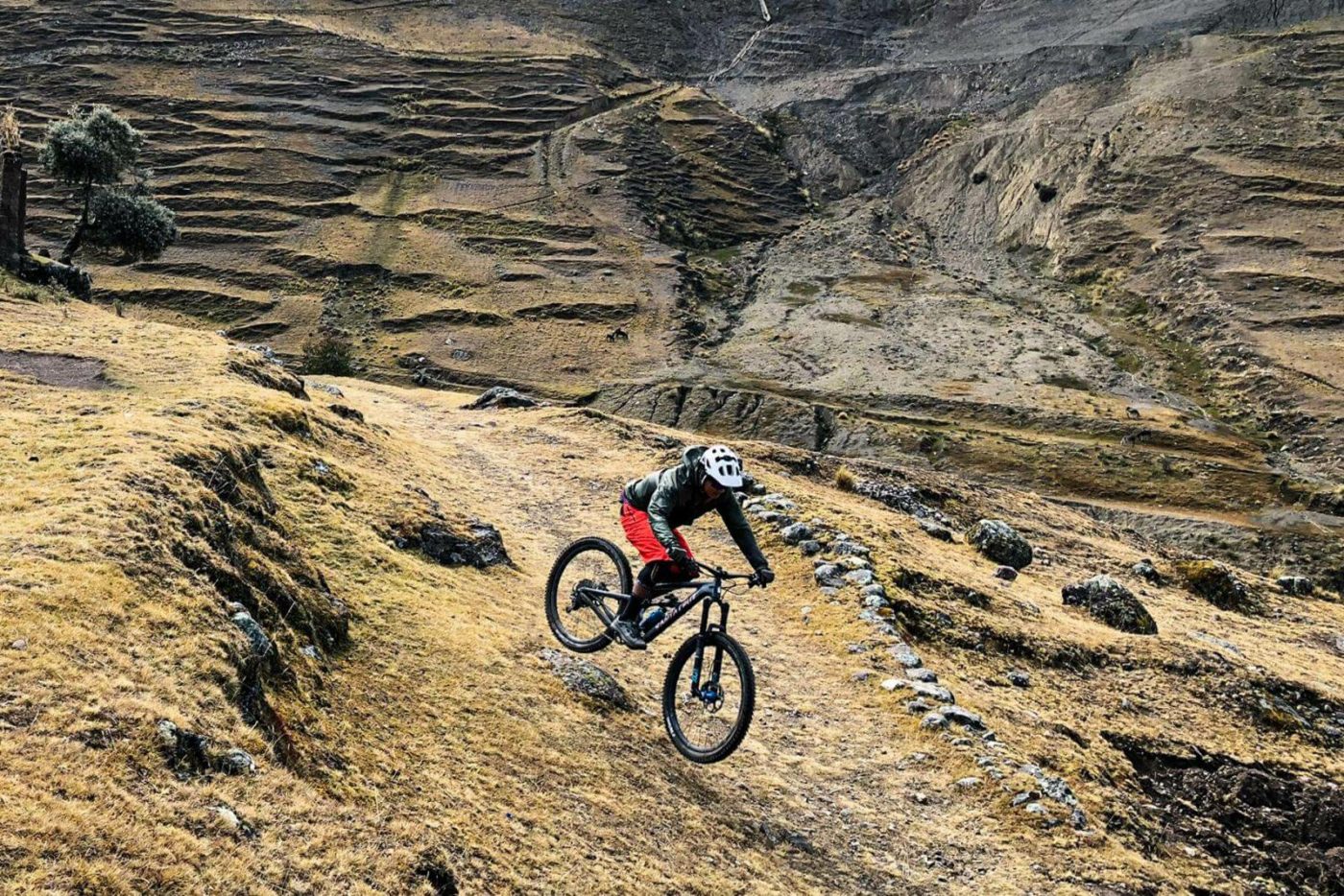 A person biking down a mountain trail in Peru.
