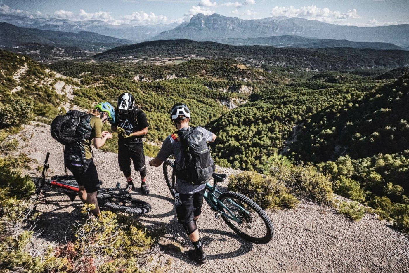 Three mountain bikers taking a break to look at fossils they found during a ride through the Pyrenees in Spain.