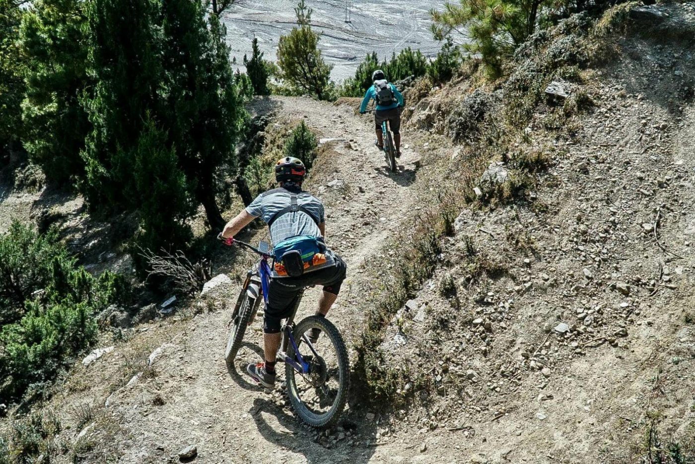 Two riders going down a mountain path in Nepal on the last day of the tour