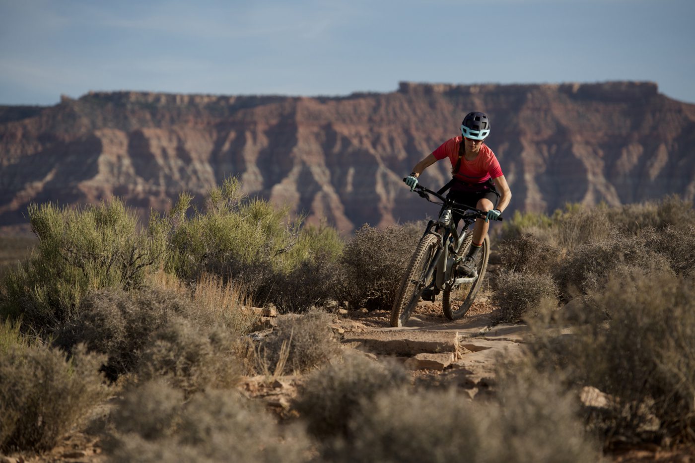 Woman in red shirt riding mountain bike