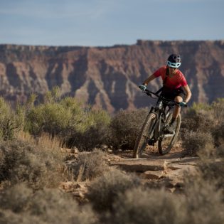 Woman in red shirt riding mountain bike