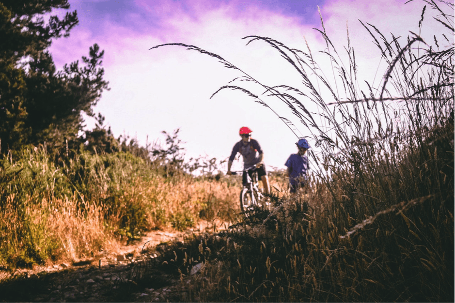 Man on Mountain Bike Talking to Kid Next to Him Wearing a Mountain Bike Helmet