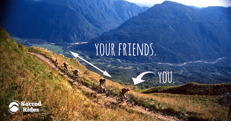 Five mountain bikers riding in a line on a trail through a mountain valley with an arrow pointing to one person that says "You" and another that says "your friends"